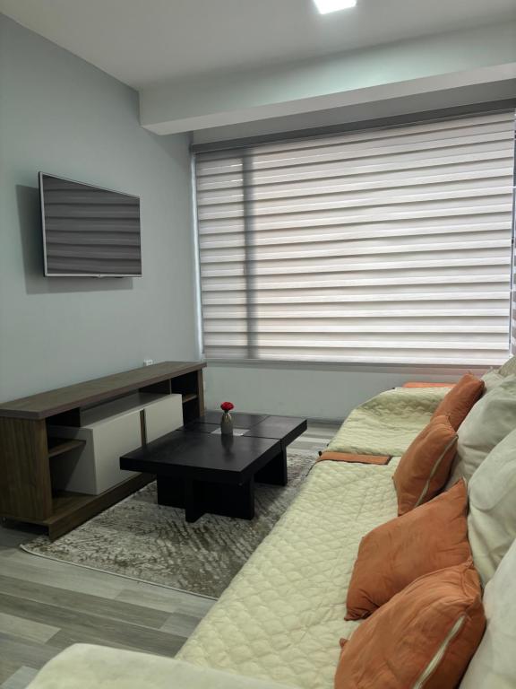 a living room with two beds and a table at Comfortable apartment in South Quito in Quito