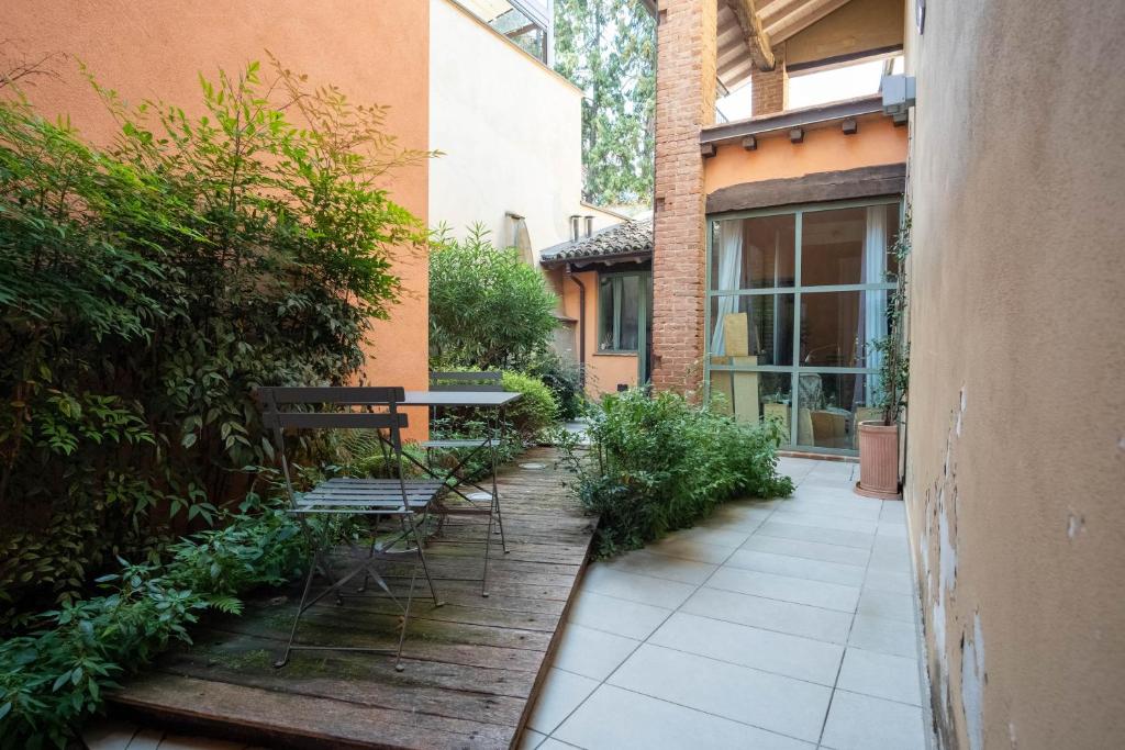 a patio with a bench and a table in a courtyard at Piacenza centro in Piacenza