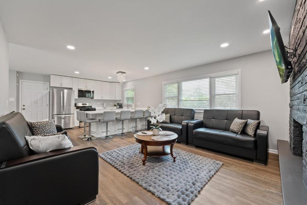 a living room with couches and a table and a kitchen at Exceptional Willowbrook Retreat in Willowbrook