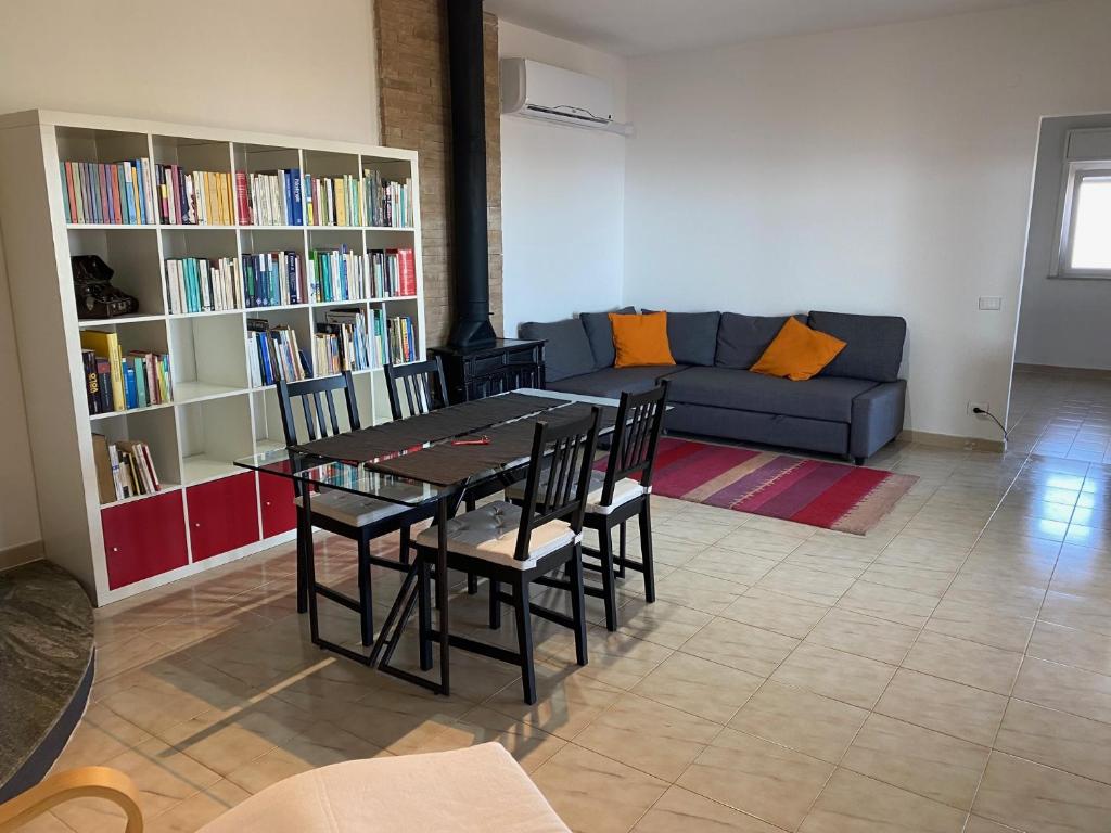 een woonkamer met een tafel, stoelen en een bank bij La Casa dell'Aviatore in Boccadifalco