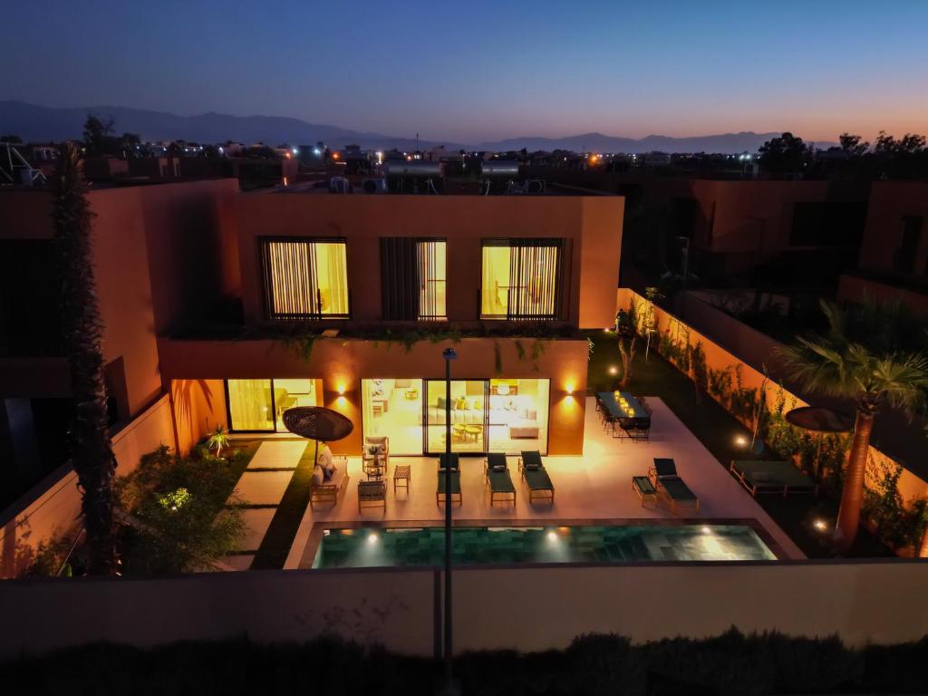 a view of a house with a swimming pool at night at Villa Marleanis 5 suites 300m2 piscine chauffée privative 11m de long résidence avec gardien in Marrakesh