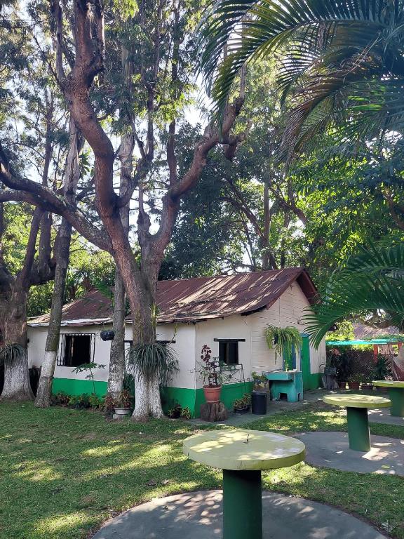 a white and green house with a tree at El Aguacatal in Panajachel