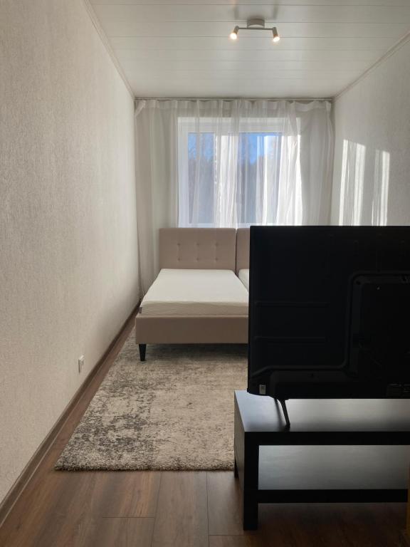 a living room with a couch and a window at Karula Stay 1-Room Apartment in Antsla