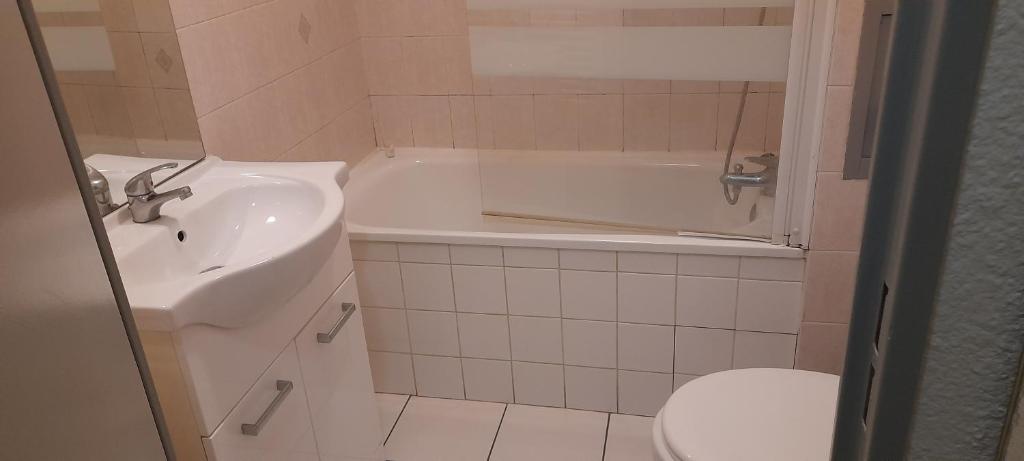 a bathroom with a sink and a tub and a toilet at Sweet Lodge in Échirolles