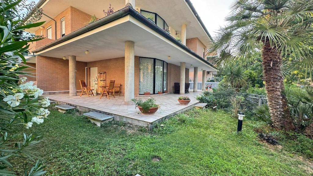 a house with a patio and a palm tree at Salseadine - Senigallia in Marzocca di Senigallia