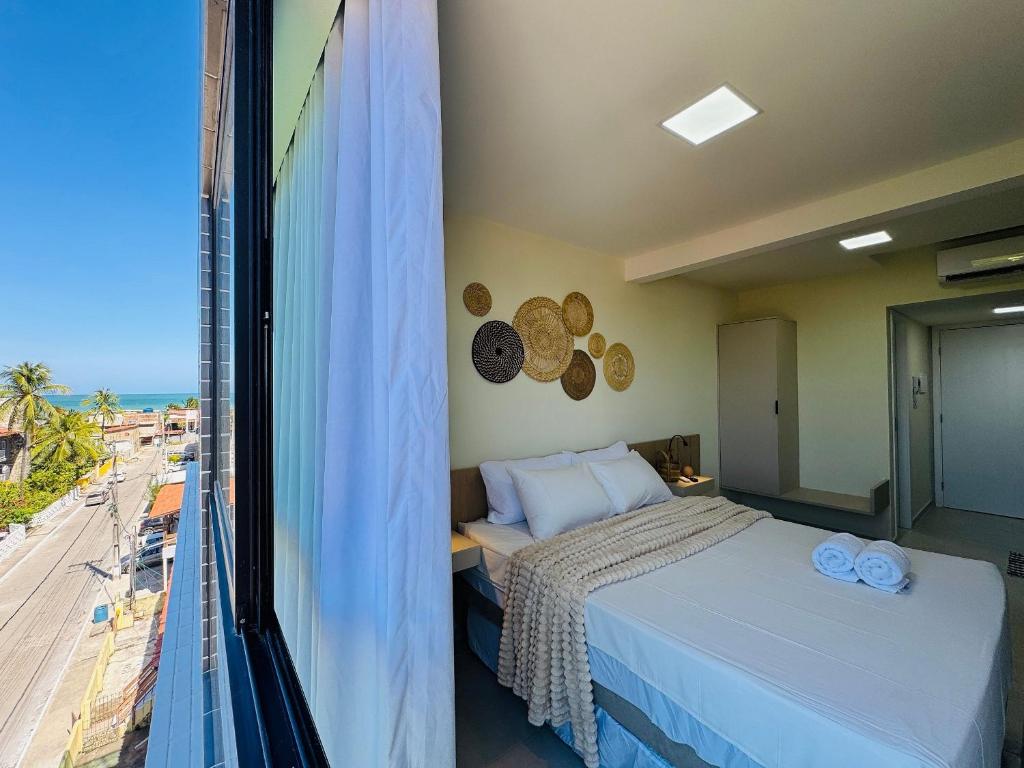 a bedroom with a bed and a view of the ocean at Mahrak Villa - VSH in Porto De Galinhas
