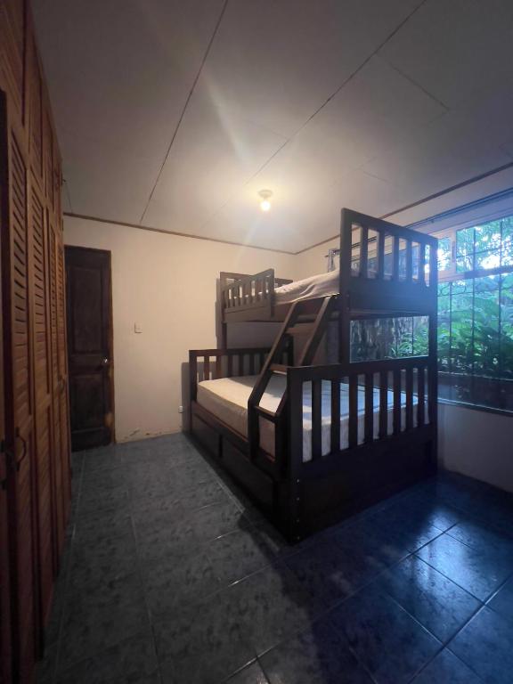 zwei Etagenbetten in einem Zimmer mit Fenster in der Unterkunft Room near Airport SJO in Coyol