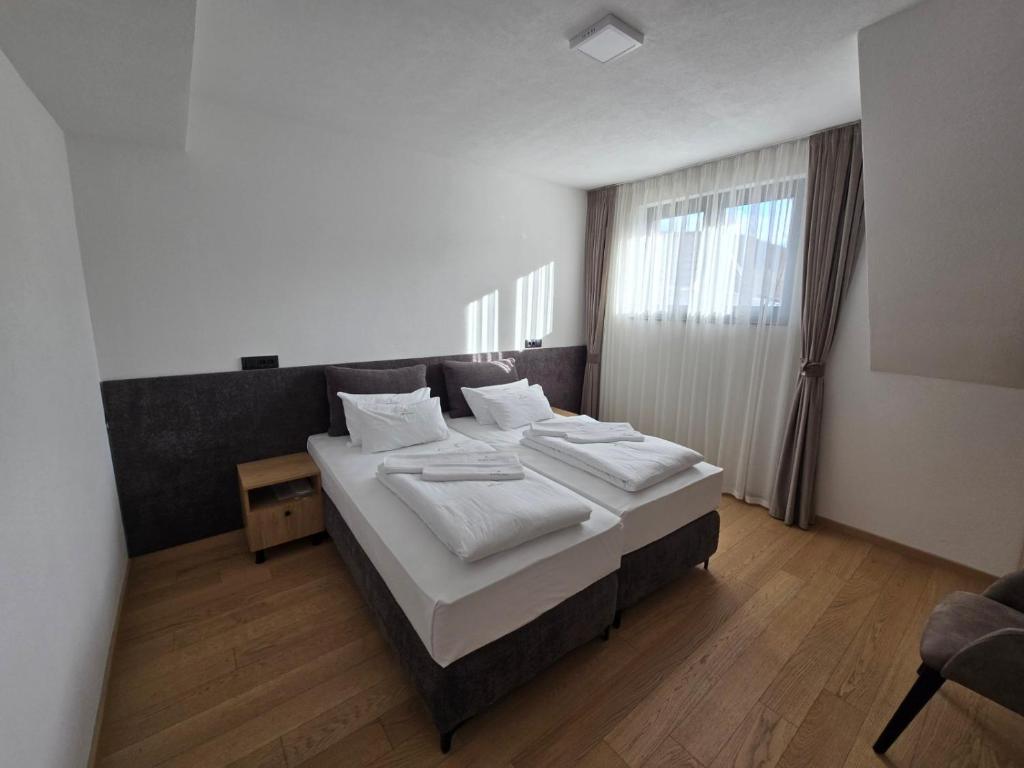 een slaapkamer met een groot bed en een raam bij Janjska Kuća in Šipovo