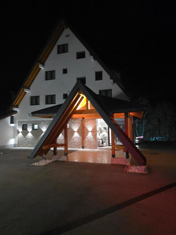 a large white building with a triangular roof at night at Janjska Kuća in Šipovo