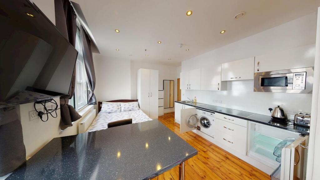 a kitchen with white cabinets and a counter top at Comfortable Studio in City Centre Nottingham in Nottingham