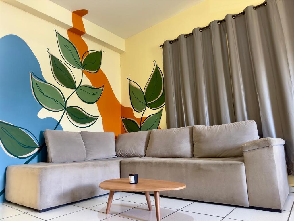 a living room with a couch and a mural at Loft Central Orgânico in Passos