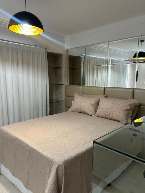 a bedroom with a large bed and a glass table at Apart estiloso! in Feira de Santana