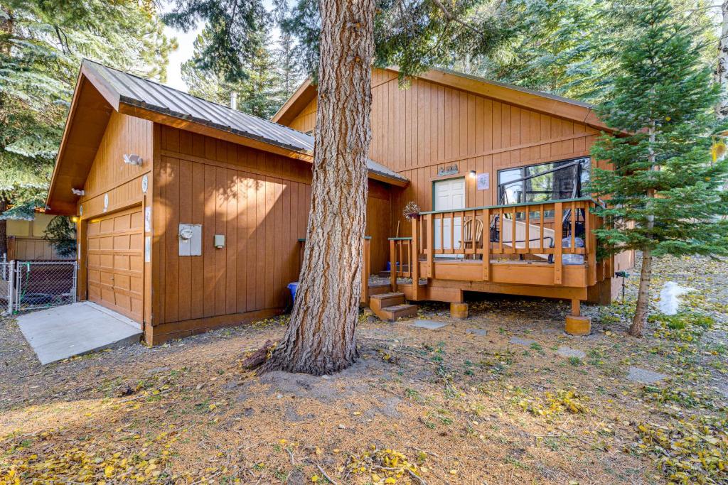 ein großes Holzhaus mit einem Baum davor in der Unterkunft 1 Mi to Skiing! Cabin Hideaway on June Lake Loop in June Lake