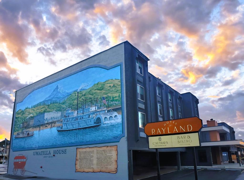 a building with a painting of a boat in the water at Rayland Hotel in The Dalles