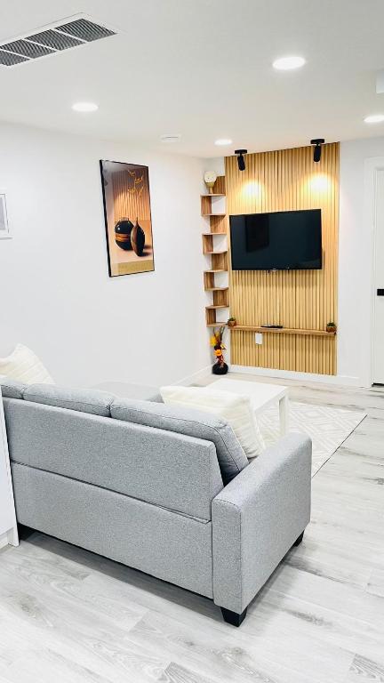 ein Wohnzimmer mit Sofa und Fernseher in der Unterkunft Ivey Homes in Edmonton