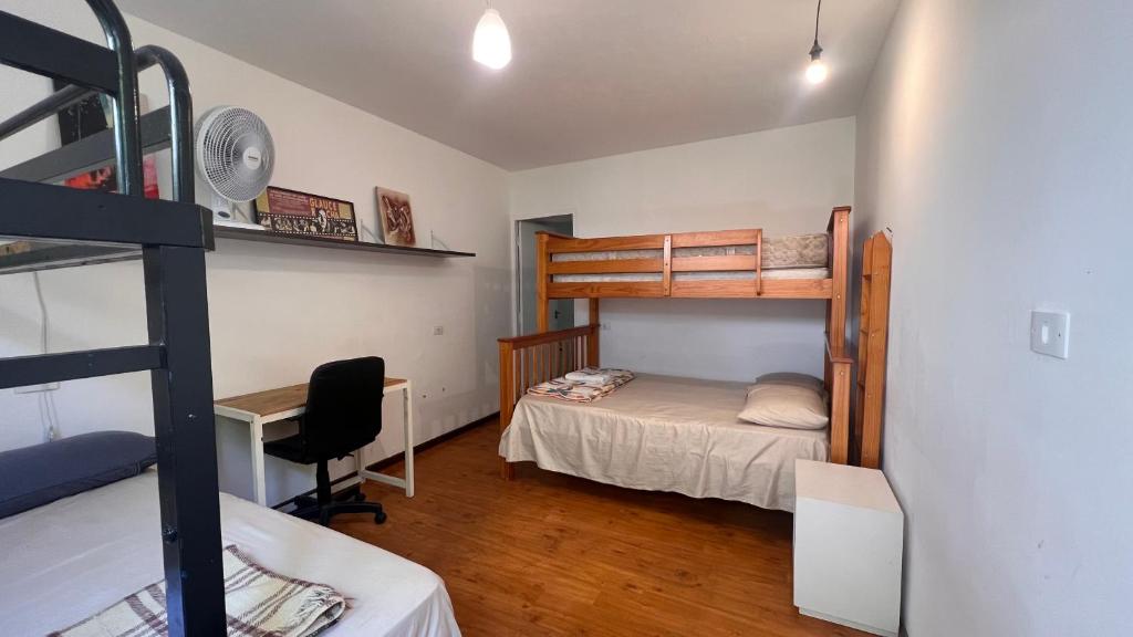 a dorm room with a bunk bed and a desk at Casa Ibirapuera - Hospedagem in Sao Paulo