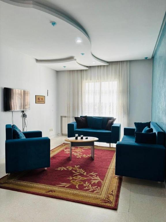 a living room with blue couches and a coffee table at Dream Appartement Monastir in Monastir