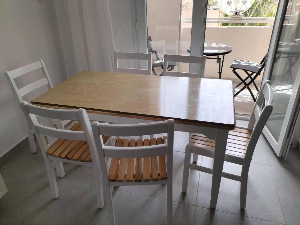 Una mesa de comedor con dos sillas y una mesa de madera. en Appartement F3 Oran, en Bir el Djir