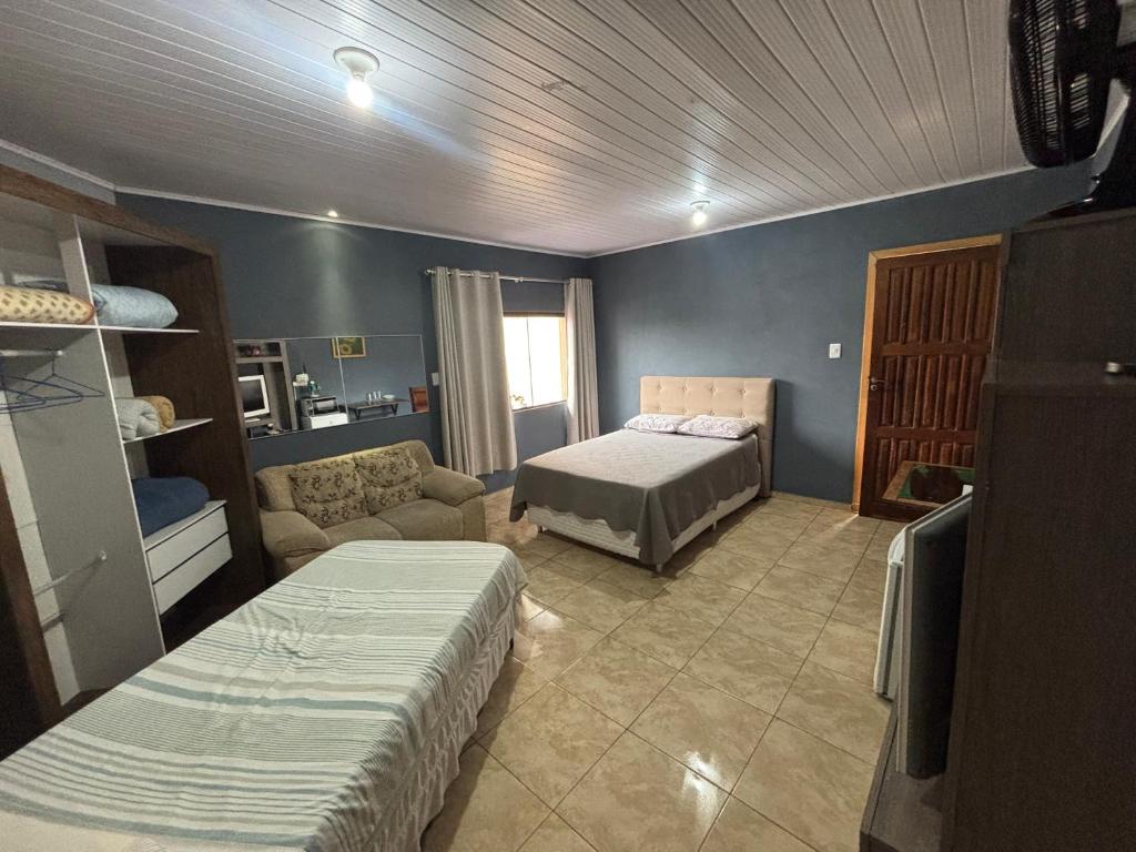 een kamer met een slaapkamer met een bed en een bank bij Suite/loft Jardim Botanico in Curitiba