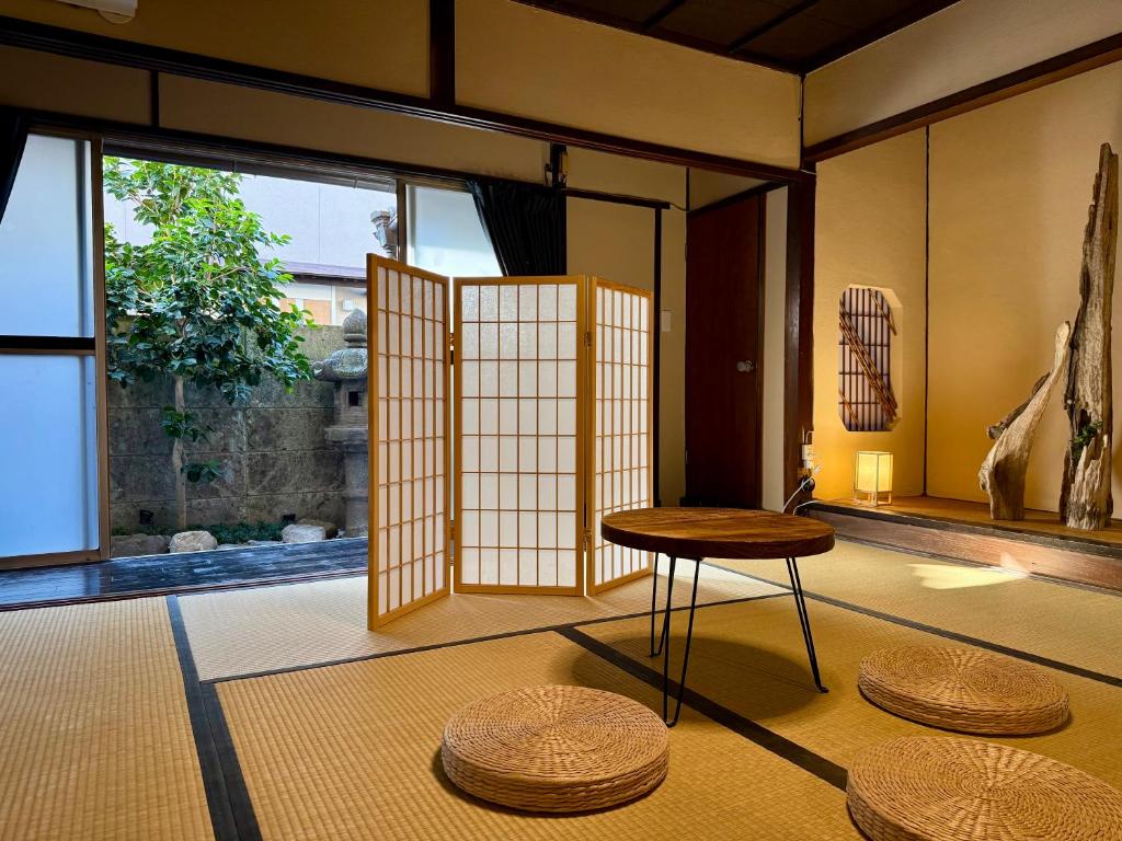 a room with a table and stools on the floor at 滋庵 jian okayama in Okayama