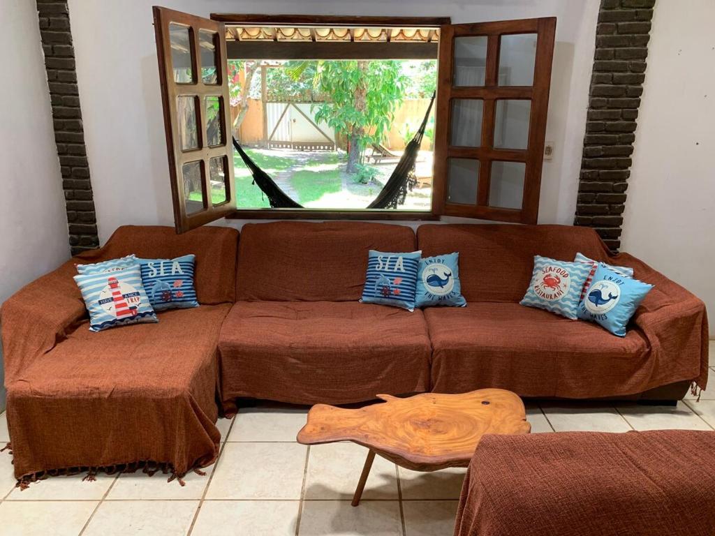 een bruine bank in een woonkamer met een raam bij Casa Baleia in Itacaré