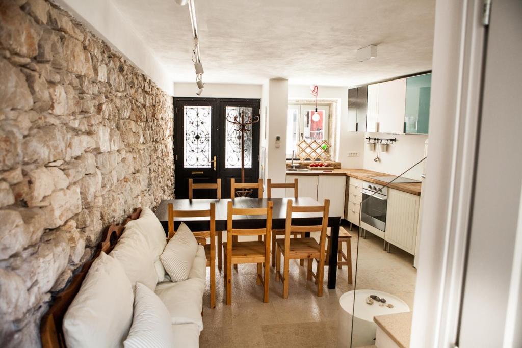 ein Wohnzimmer mit einem Tisch und einer Steinmauer in der Unterkunft Casa Allegra - House da papà in Rovinj
