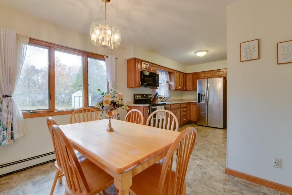 a kitchen and dining room with a wooden table and chairs at 15 Mi to Cochrans Ski Area Cozy Home with Yard! in Essex Junction