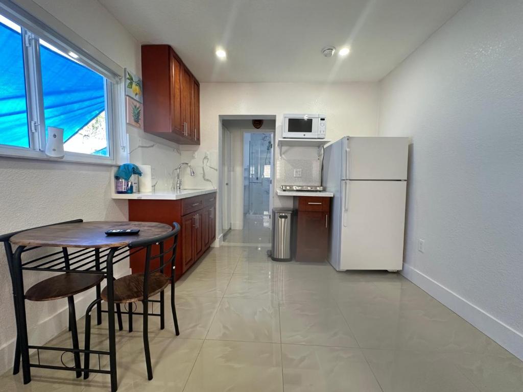 Una pequeña cocina con una mesa y un refrigerador. en Miramar's Studio, en Miramar
