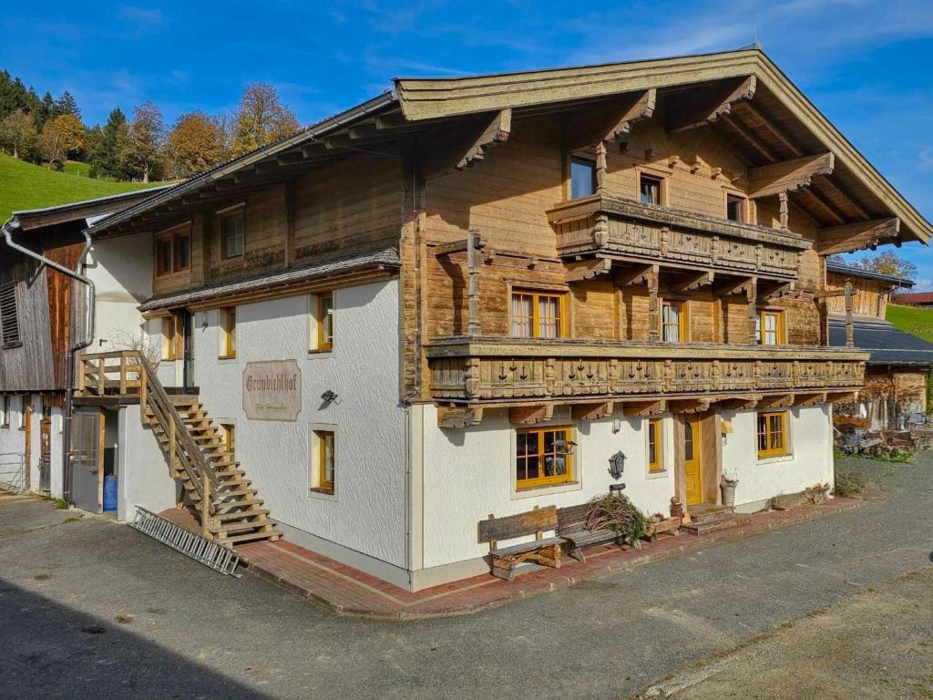 a large wooden building with a porch and a staircase at Grünbichel Hof I in Lengdorf