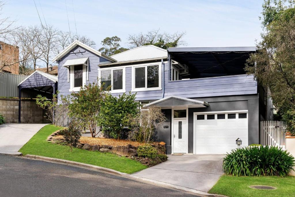 una casa blu con un garage bianco di Tranquil Suites in Heart of Leura 3 Minutes to Shops a Leura