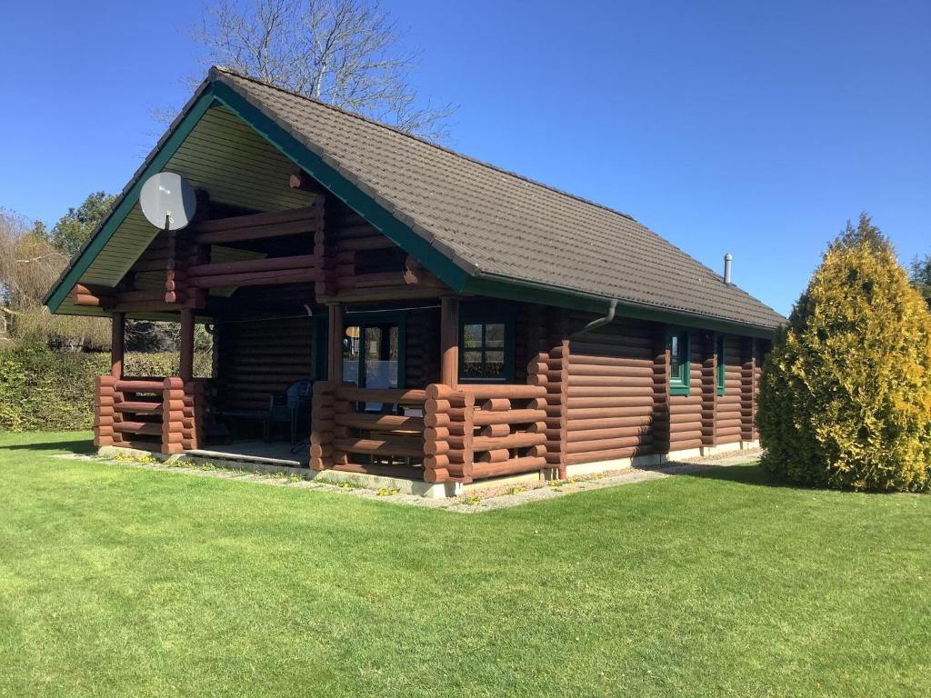een blokhut met een groen gazon ervoor bij Blockhaus in Burhave in Hoddersdeich