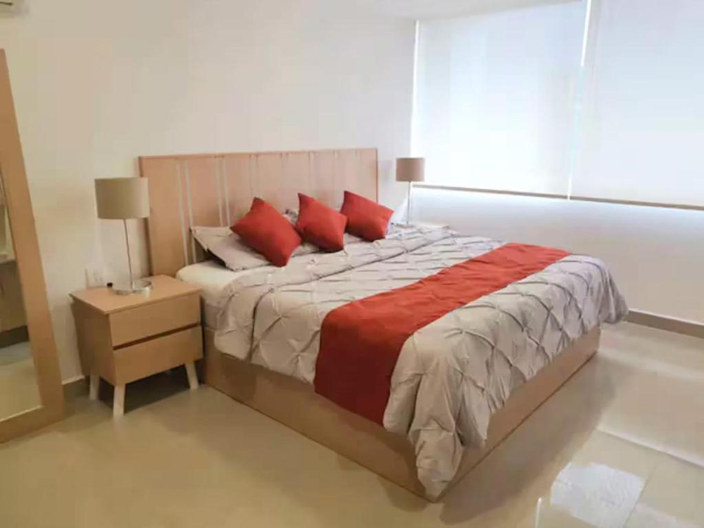 een slaapkamer met een groot bed met rode kussens bij 16 Loft Espectacular - Aire Acondicionado, Consulado in Guadalajara