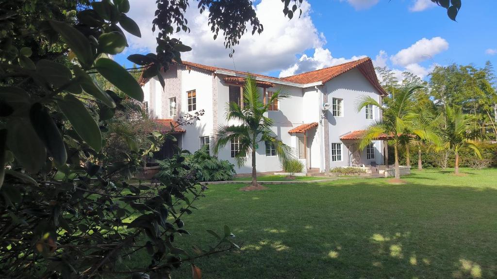 a large white house with a grass yard at CASA HOTEL FIBA MAGUEZA in San Francisco