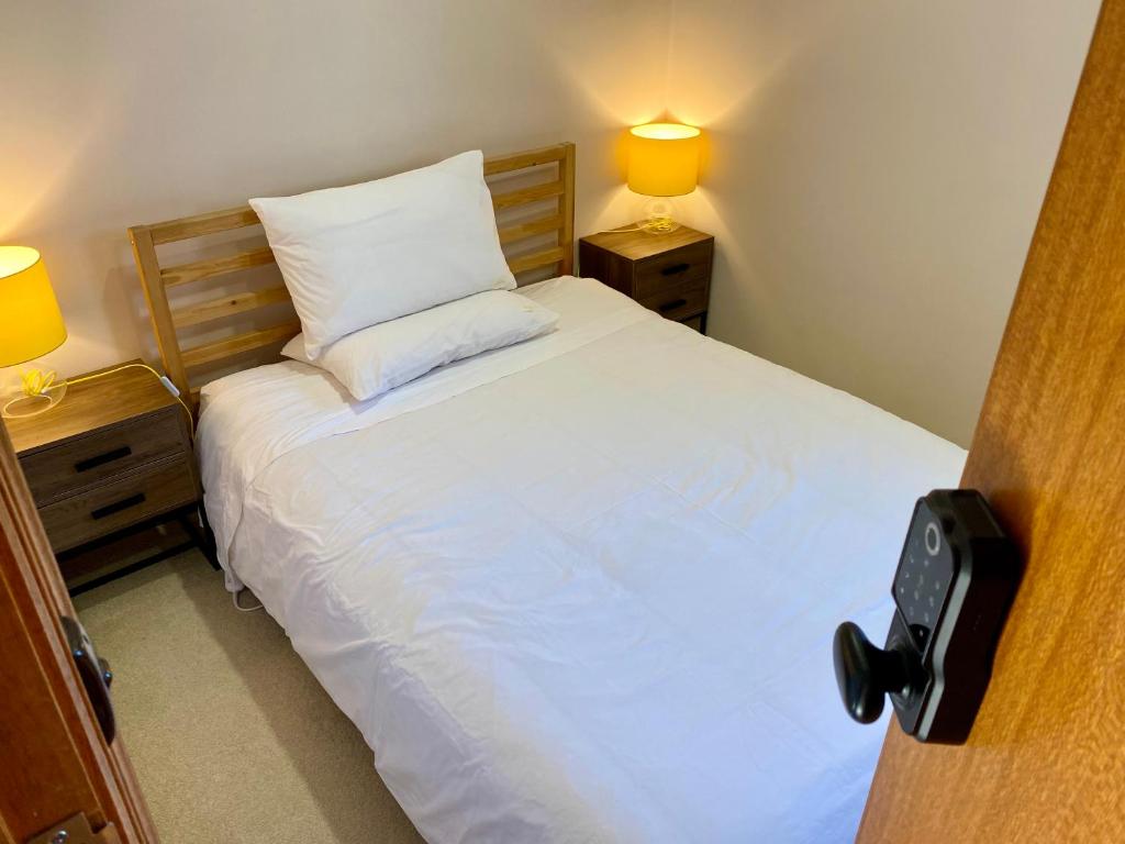 a bedroom with a bed with two night stands and two lamps at Hillside Retreat With Pool in Flagstaff Hill