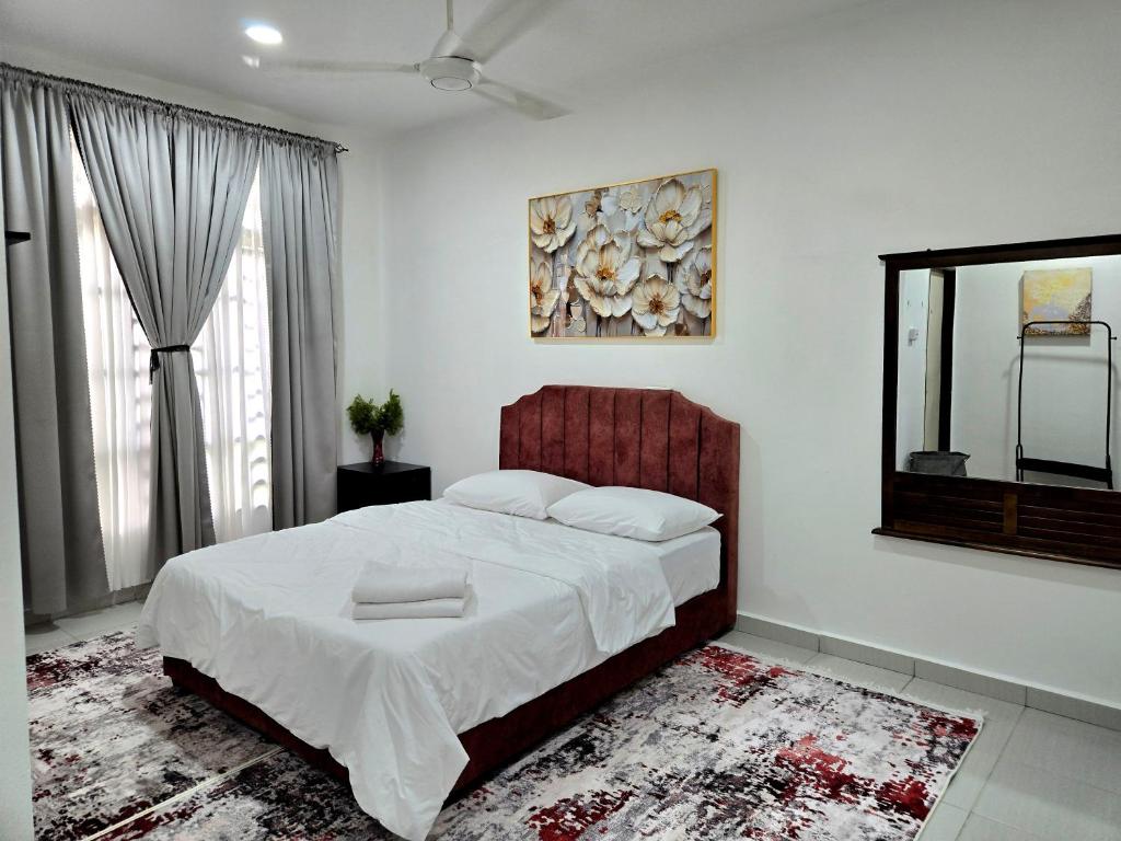 a bedroom with a large bed and a mirror at Homestay BAYT AL - JAZMY in Kuantan