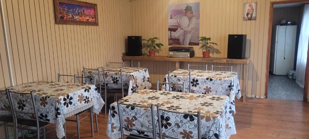 a room with four tables and chairs with white table cloth at Casa Club in Puerto Montt