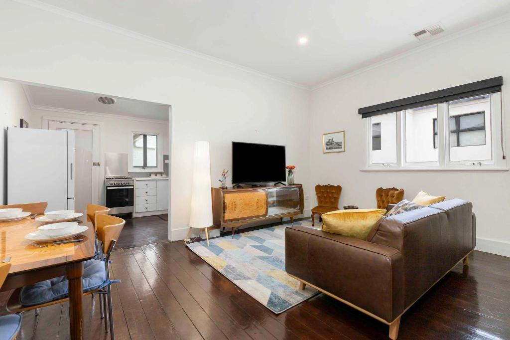 a living room with a couch and a table at The Golden Key Henley Beach in Henley Beach South