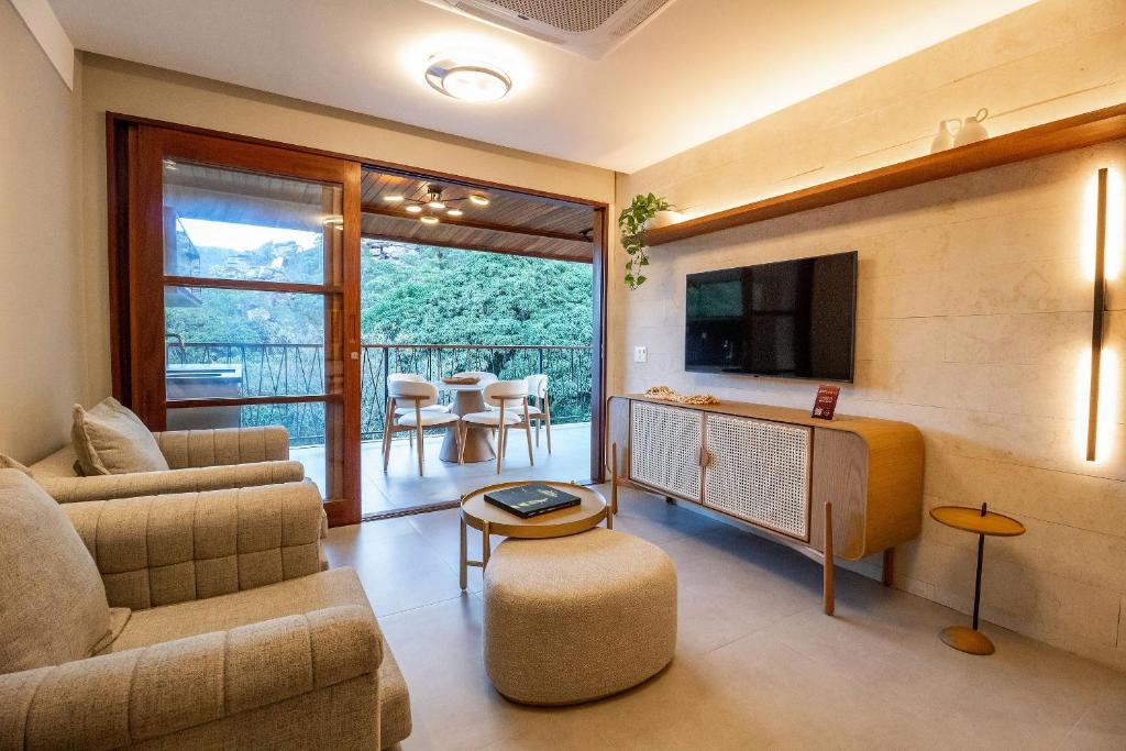 a living room with a couch and a tv at Apartamento Luxuoso com Vista para as Montanhas in Mucugê