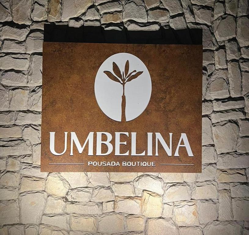 una señal en el costado de una pared de piedra en Umbelina Pousada Boutique, en Porto de Galinhas