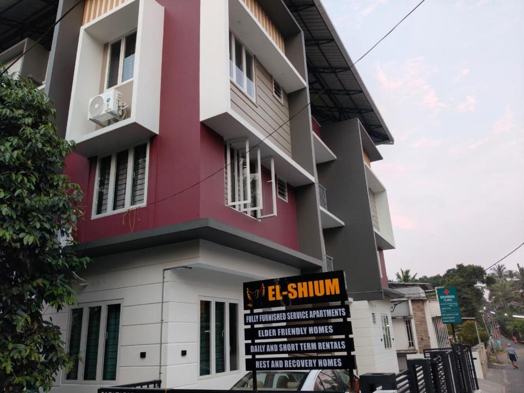 a building with a sign in front of it at ElShium Homes in Cochin