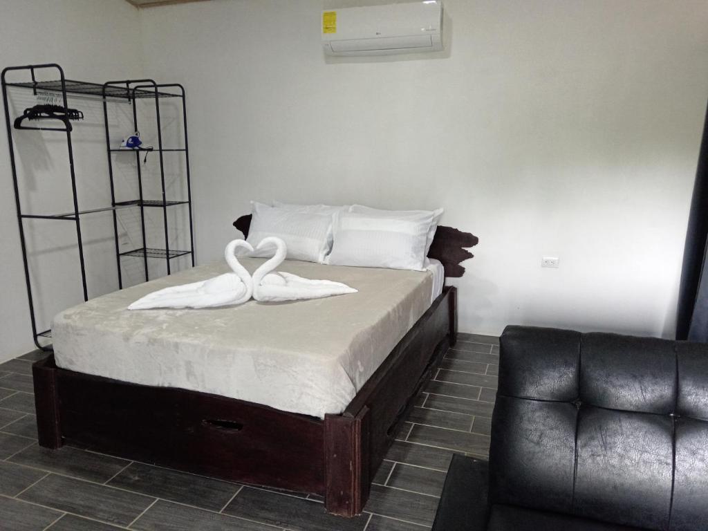 Un dormitorio con una cama con dos cisnes encima. en Pino Lodge, Río Celeste, en Upala