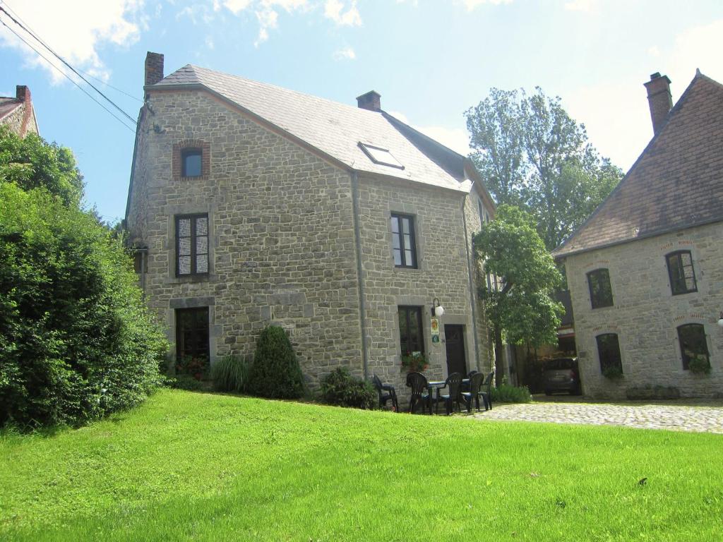 a large brick building with a grass yard at Riverside Retreat Viroinval in Treignes