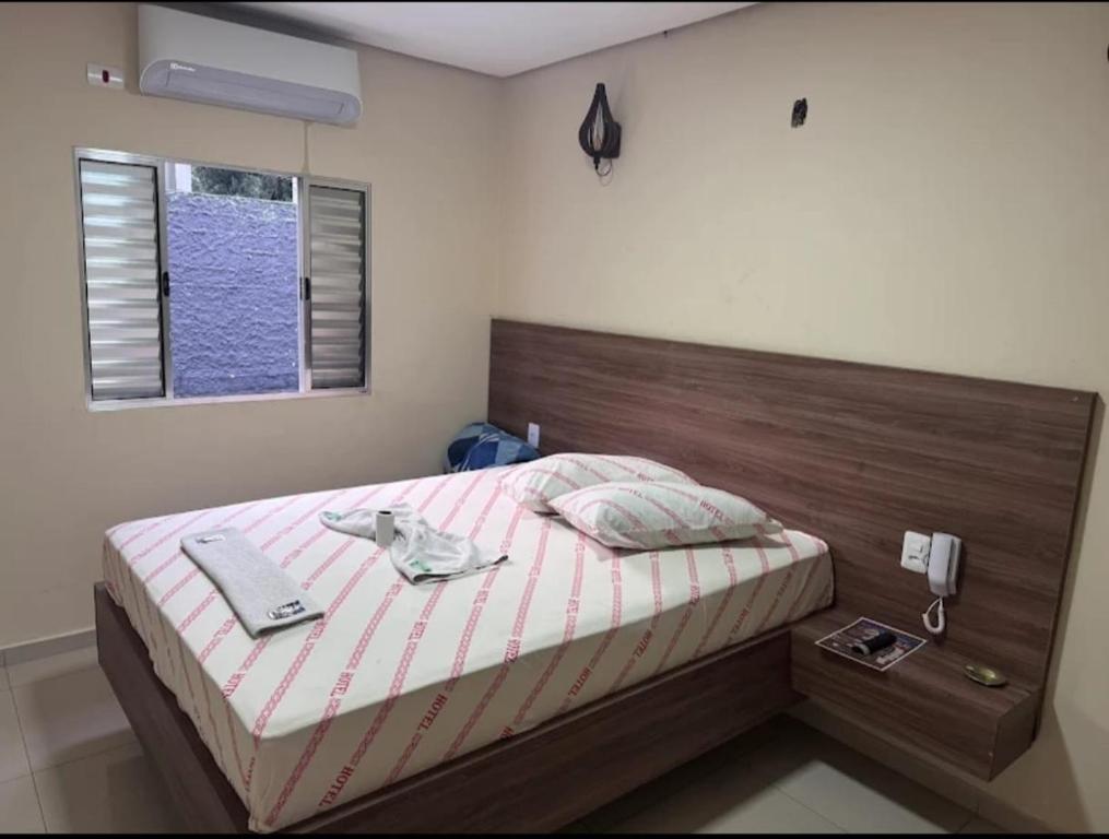 Un dormitorio con una cama con cabecero de madera. en Hotel Oasis, en São Paulo
