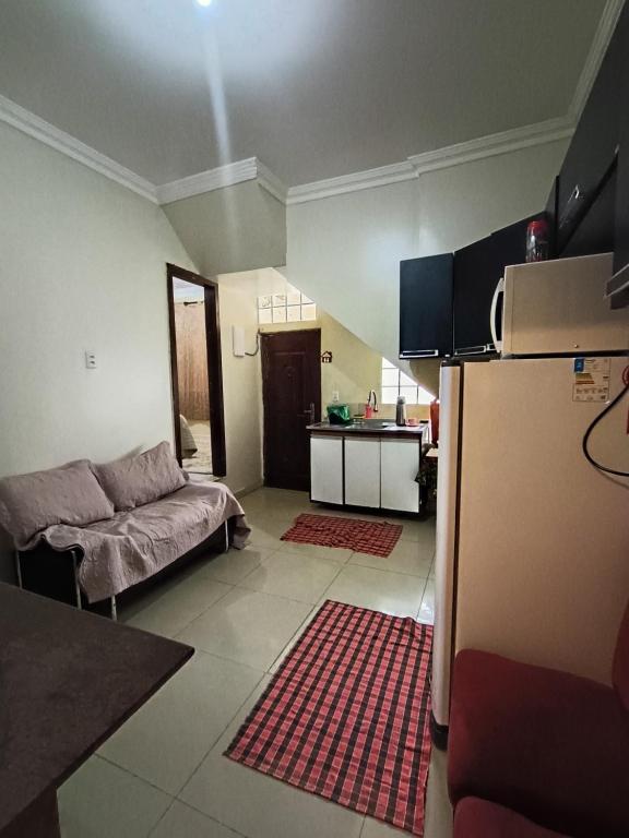 eine Küche und ein Wohnzimmer mit einem Sofa und einem Kühlschrank in der Unterkunft Apto inteiro 3 quartos, sendo duas suítes in Belém