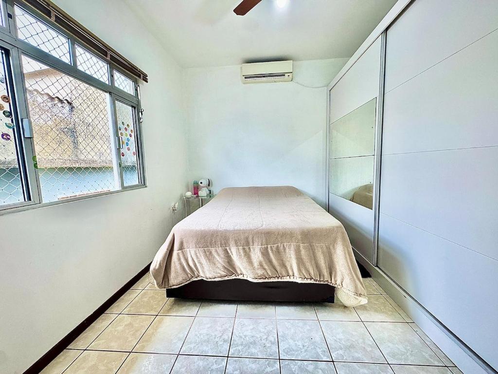 een slaapkamer met een bed in een kamer met een raam bij Serra e Mar 2 in São José