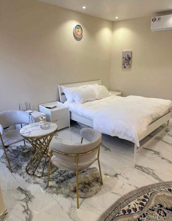 a bedroom with a bed and a table and chairs at عزبة وادي السدر in ‘Ashashah