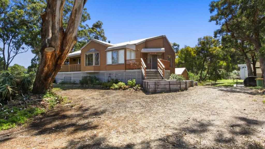 a wooden house with a tree in front of it at Halcyon - Peaceful Family Retreat in Nungurner