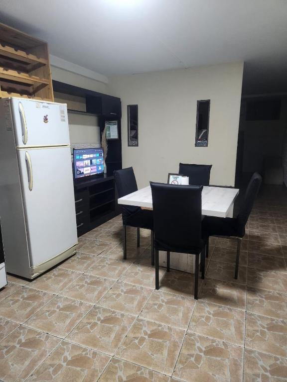 a kitchen with a white refrigerator and a table and chairs at la pipi in Las Heras