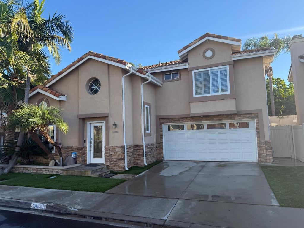 a large house with a white garage door at South OC House in Laguna Niguel