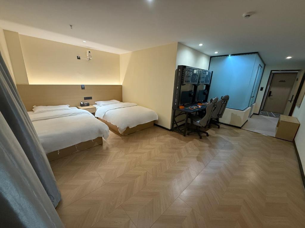 a hotel room with two beds and a desk at Hulk Esports Cinema Hotel Guiyang Fountain Pool Branch in Guiyang